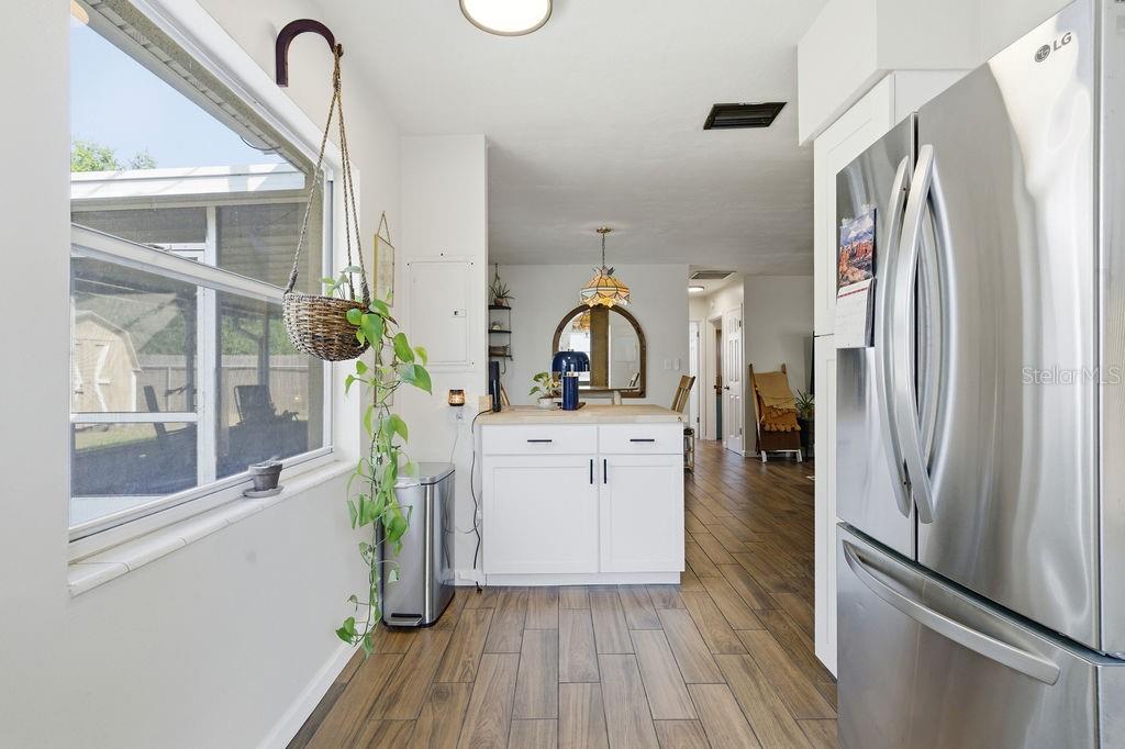 8520 109th Way North Seminole, FL 33772 - Photo 10 of 40 a kitchen with stainless steel appliances a refrigerator a stove a sink and a window with wooden floor