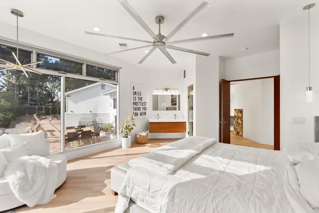 a bedroom with a large bed and a chandelier