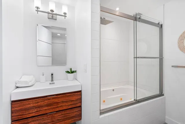 a bathroom with a shower sink and mirror