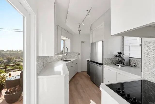 a kitchen with stainless steel appliances granite countertop a sink a stove and a refrigerator