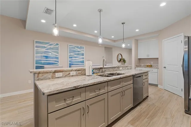 a kitchen with refrigerator and chairs