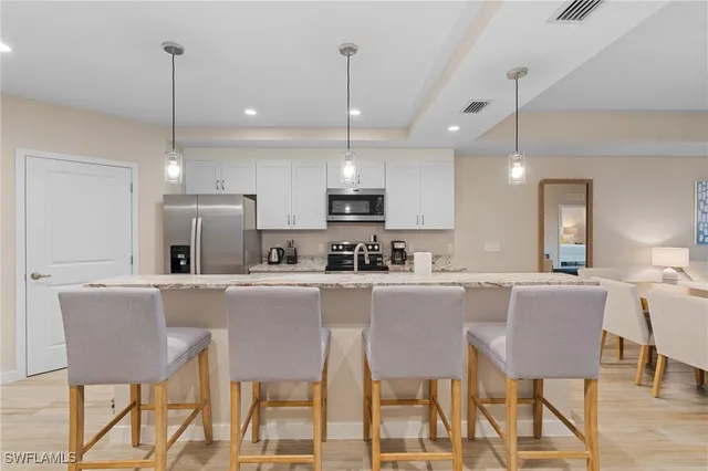 a kitchen with white cabinets and stainless steel appliances