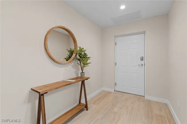 a kitchen with stainless steel appliances granite countertop a refrigerator a stove top oven a sink dishwasher and a dining table with wooden floor