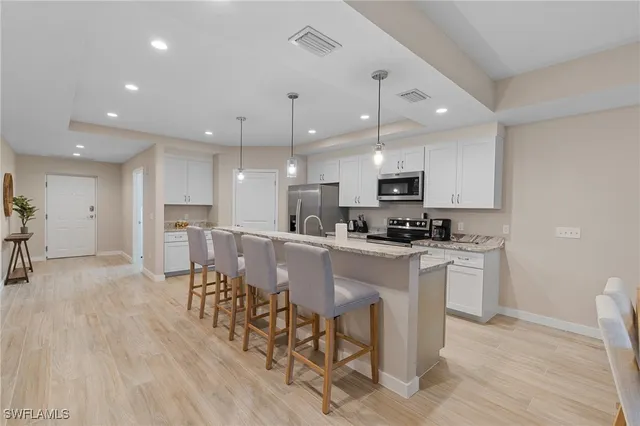 a kitchen with kitchen island a sink stainless steel appliances and window