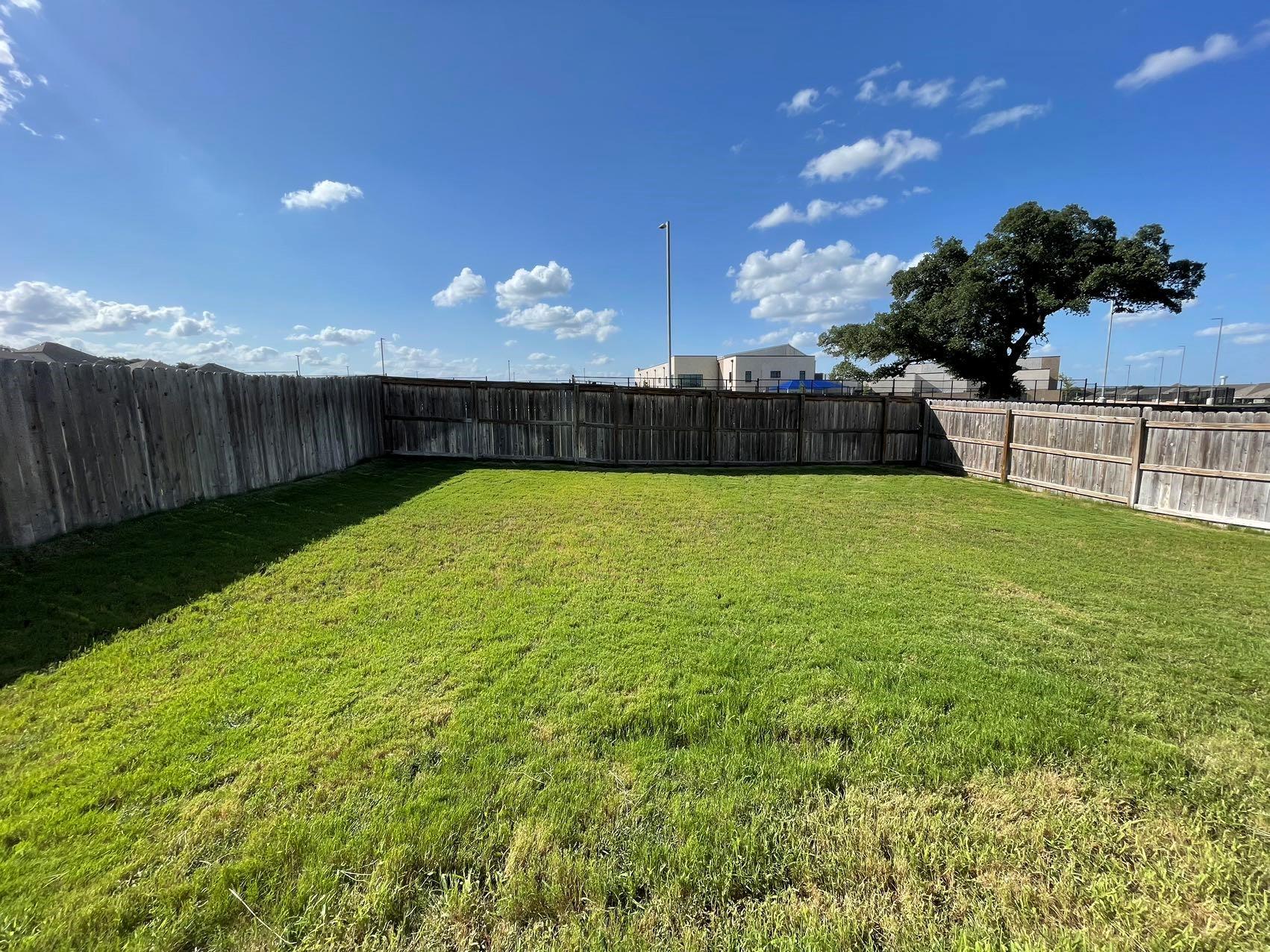 1625 Woolsey Way Leander, TX 78641 - Photo 17 of 17 The property includes a spacious backyard with a lawn, enclosed by a wooden fence