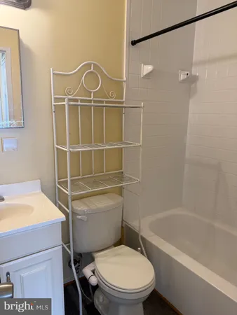 a white toilet sitting next to a bath tub