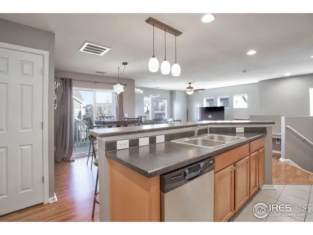 a kitchen with stainless steel appliances granite countertop a sink a stove and a wooden floors