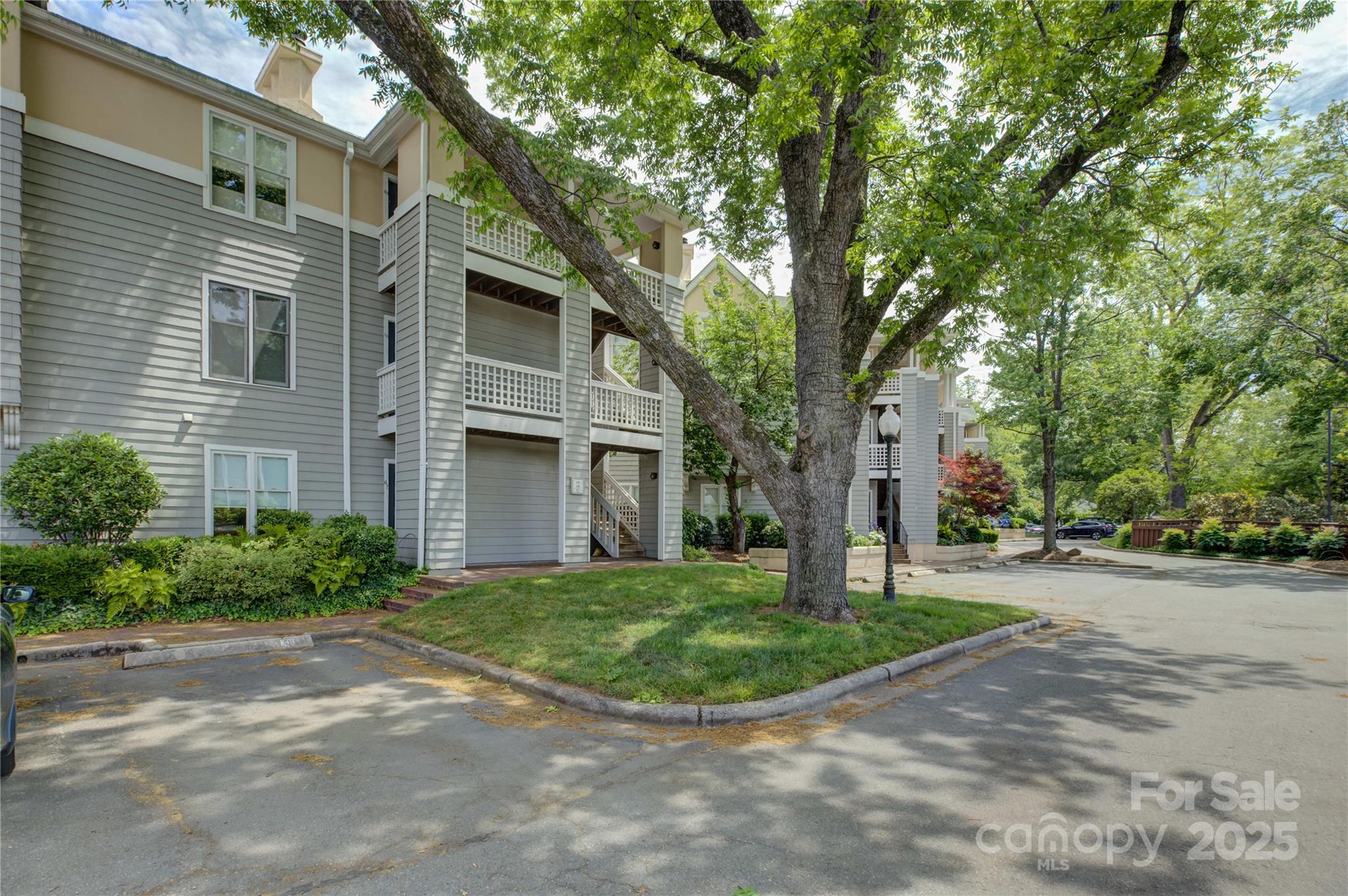 226 Queens Road, Unit 68 Charlotte, NC 28204 - Photo 2 of 40 a view of a brick house with a yard and large trees