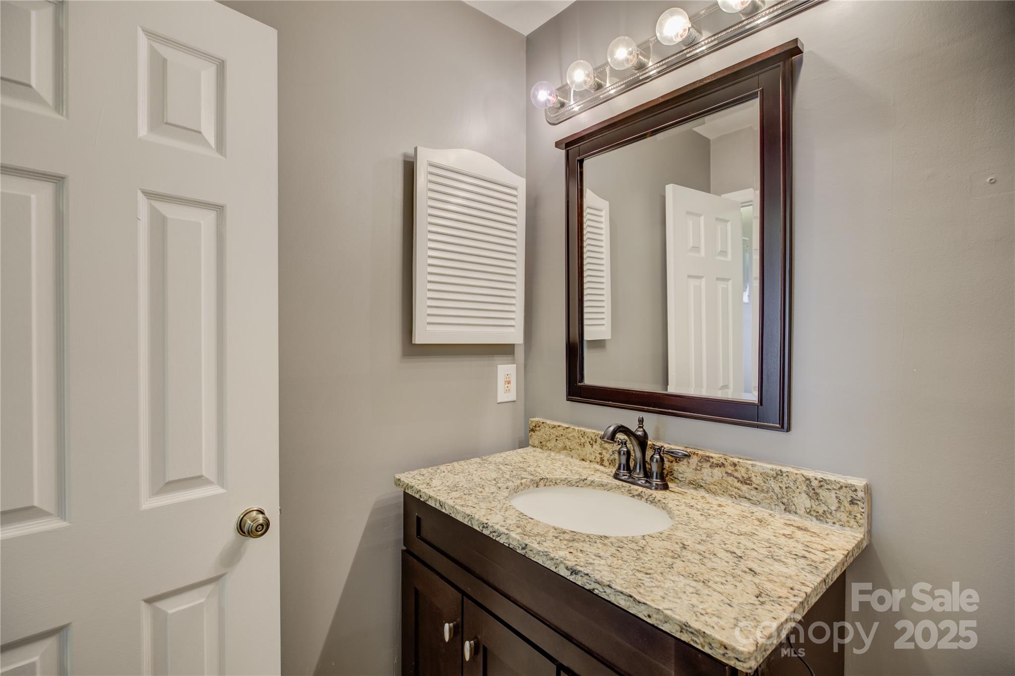 226 Queens Road, Unit 68 Charlotte, NC 28204 - Photo 30 of 40 a bathroom with a granite countertop sink and a mirror