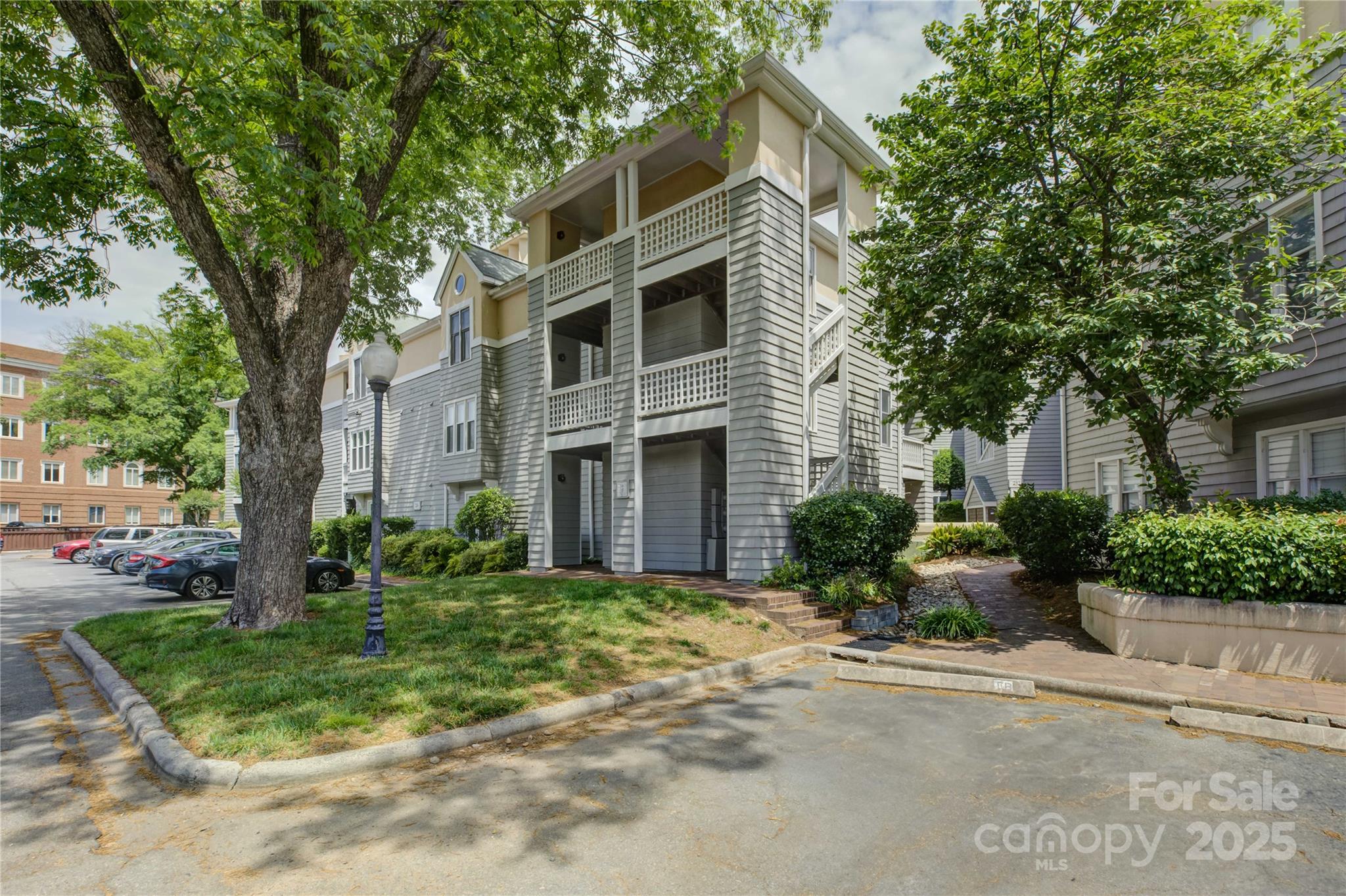 226 Queens Road, Unit 68 Charlotte, NC 28204 - Photo 3 of 40 a front view of a house with a yard and trees