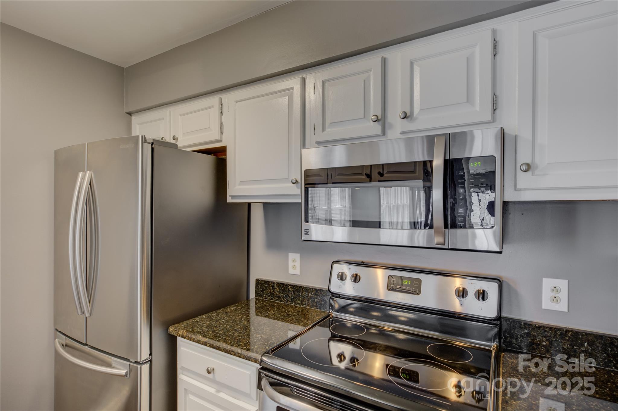 226 Queens Road, Unit 68 Charlotte, NC 28204 - Photo 6 of 40 a kitchen with stainless steel appliances granite countertop a refrigerator and a stove