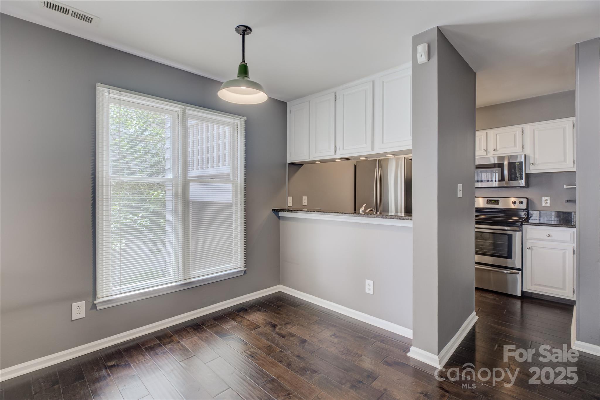 226 Queens Road, Unit 68 Charlotte, NC 28204 - Photo 8 of 40 a kitchen with granite countertop a refrigerator and a stove top oven