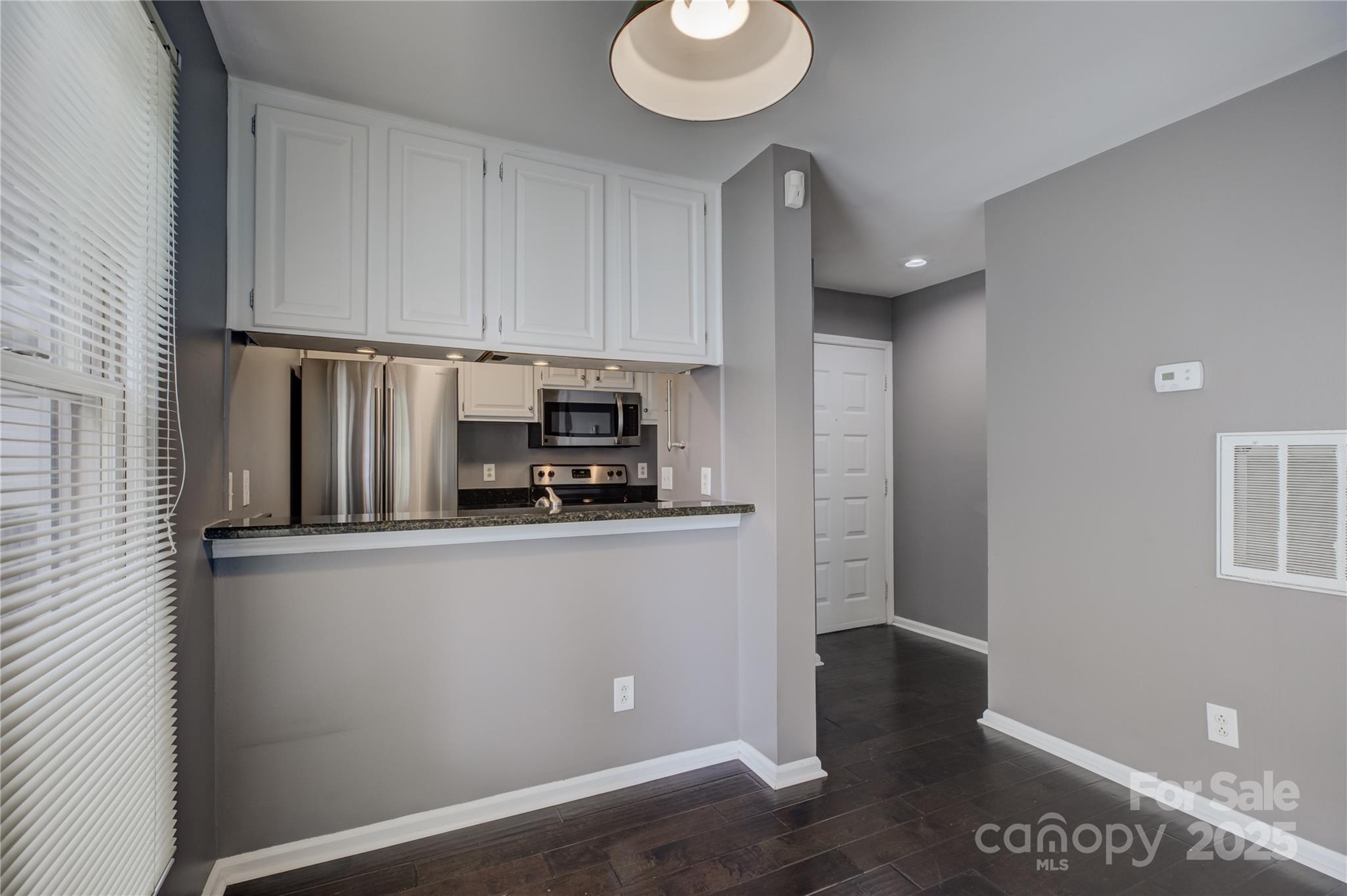 226 Queens Road, Unit 68 Charlotte, NC 28204 - Photo 9 of 40 a kitchen with stainless steel appliances a sink a stove a microwave and cabinets