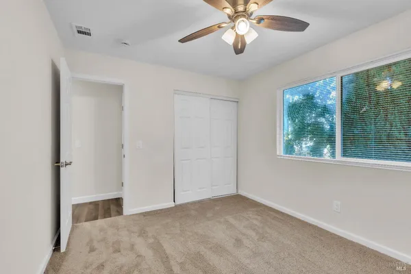 a view of a livingroom with a ceiling fan and window