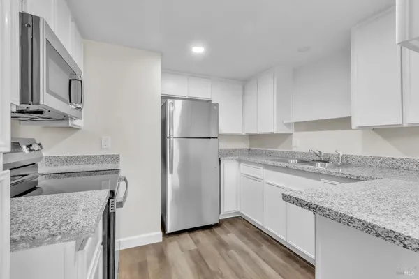a kitchen with stainless steel appliances granite countertop a refrigerator and a stove top oven