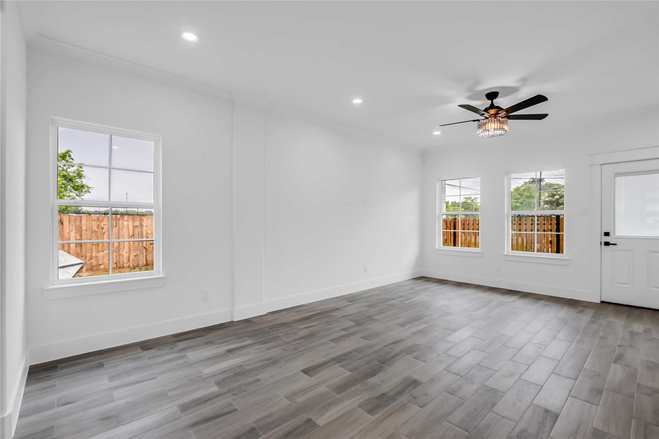 3168 Golfcrest Houston, TX 77087 - Photo 16 of 30 This inviting living room boasts sleek wood floors, abundant natural light through ample windows, and a stylish ceiling fan, creating a perfect blend of comfort and modern elegance.