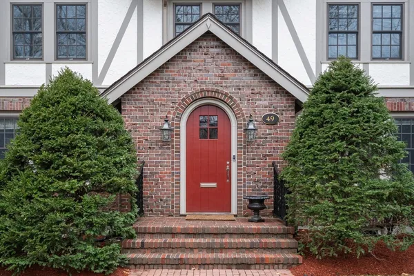 a view of a brick house with plants and large windows