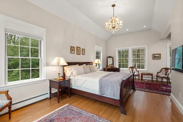 a spacious bedroom with a bed and a chandelier