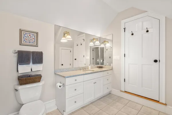 a spacious bathroom with a granite countertop sink toilet a mirror and shower