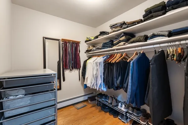 a view of walk in closet with clothes and shoes