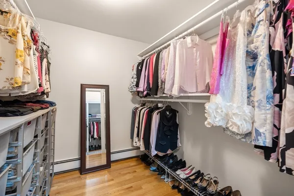 a view of walk in closet with clothes and shoes