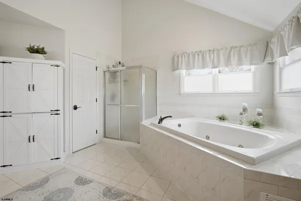 a large white bathroom with a sink and a mirror