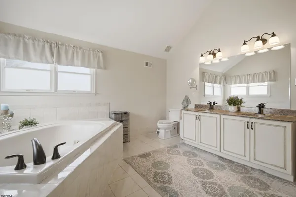 a spacious bathroom with a granite countertop sink a mirror and shower