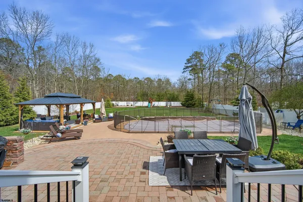 a view of a patio with couches and a fire pit and a barbeque