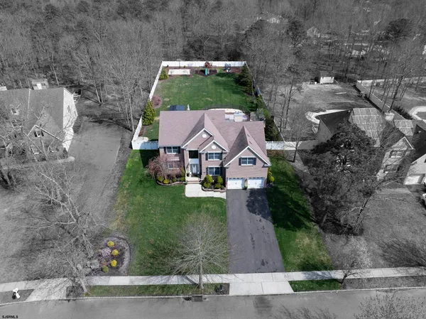 a aerial view of a house with a yard and large trees
