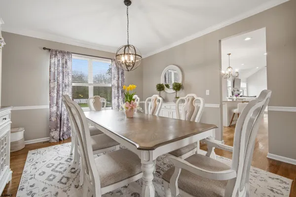 a dining room with furniture a chandelier and wooden floor