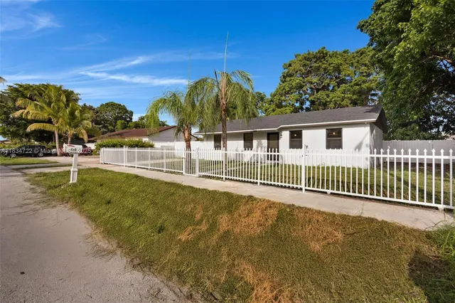 a view of a house with a backyard and a tree