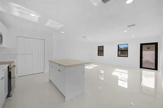 a view of a hallway with stainless steel appliances