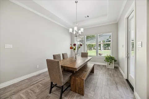 a kitchen with granite countertop a table chairs stove and wooden floor