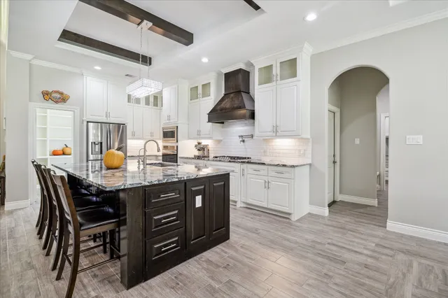 a kitchen with granite countertop a table chairs stove and wooden floor