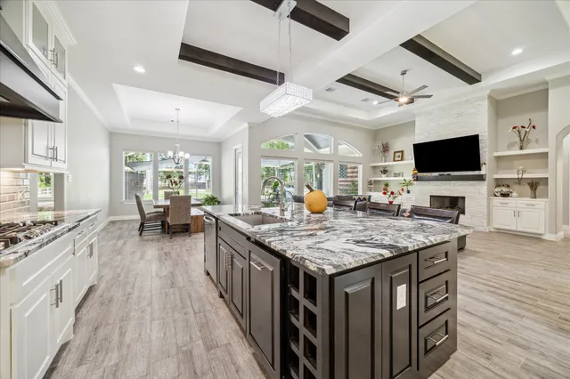a kitchen with stainless steel appliances granite countertop a stove and a wooden floors