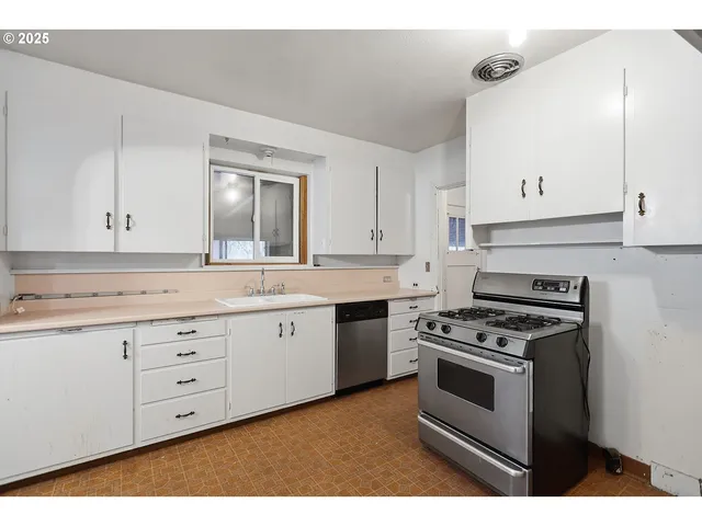 a kitchen with granite countertop white cabinets and white appliances