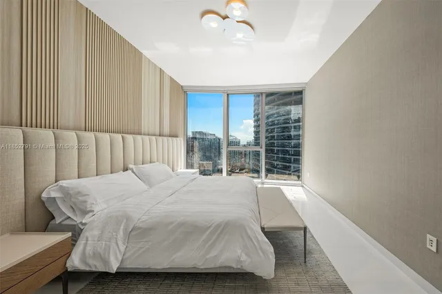 a bedroom with a bed and a large window with outer view