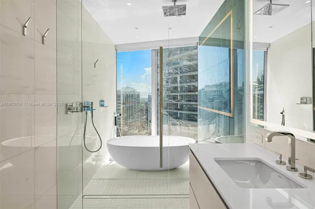 a bathroom with a granite countertop sink a mirror and a shower