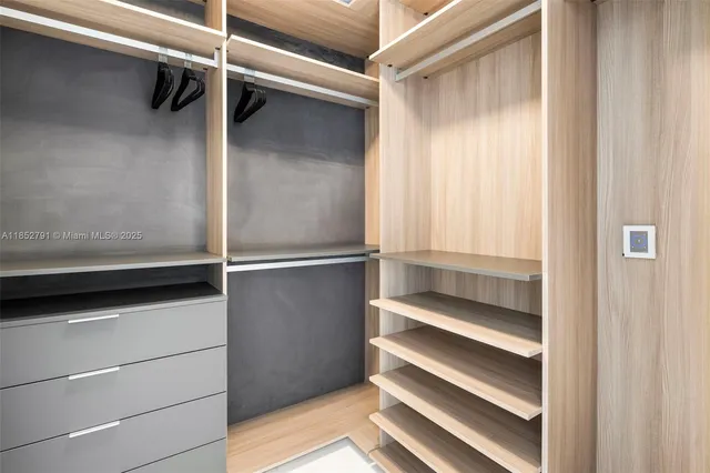 a view of walk in closet with empty racks