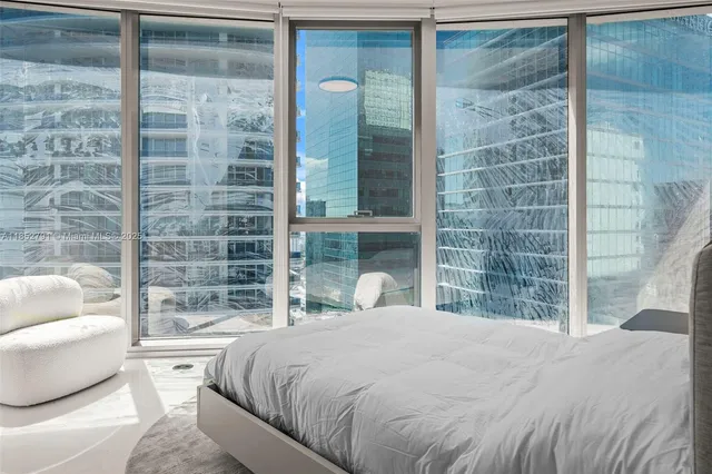 a bedroom with a large bed and a large window