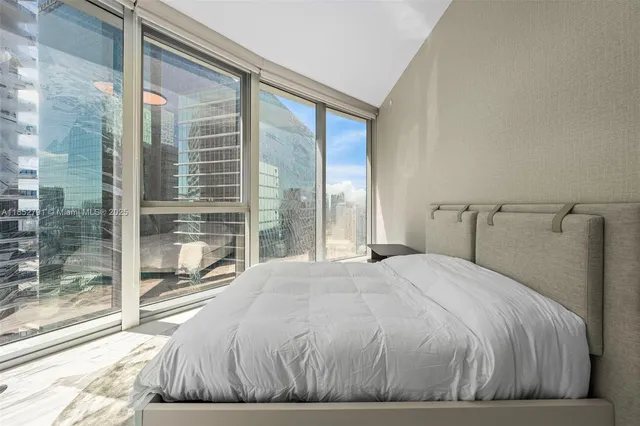 a bedroom with a large bed and a large window
