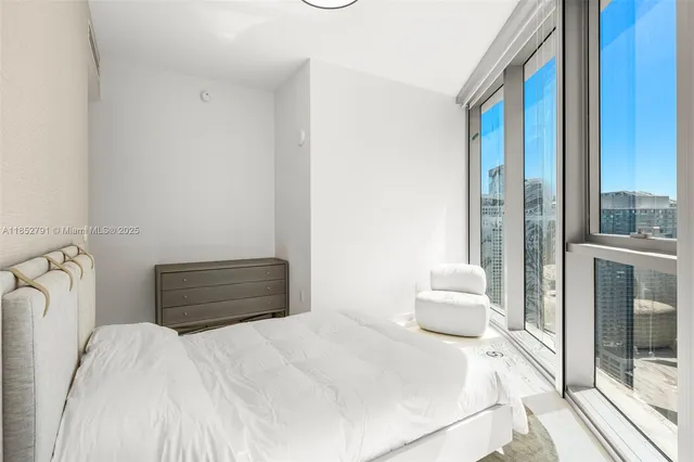 a bedroom with a bed and a large window