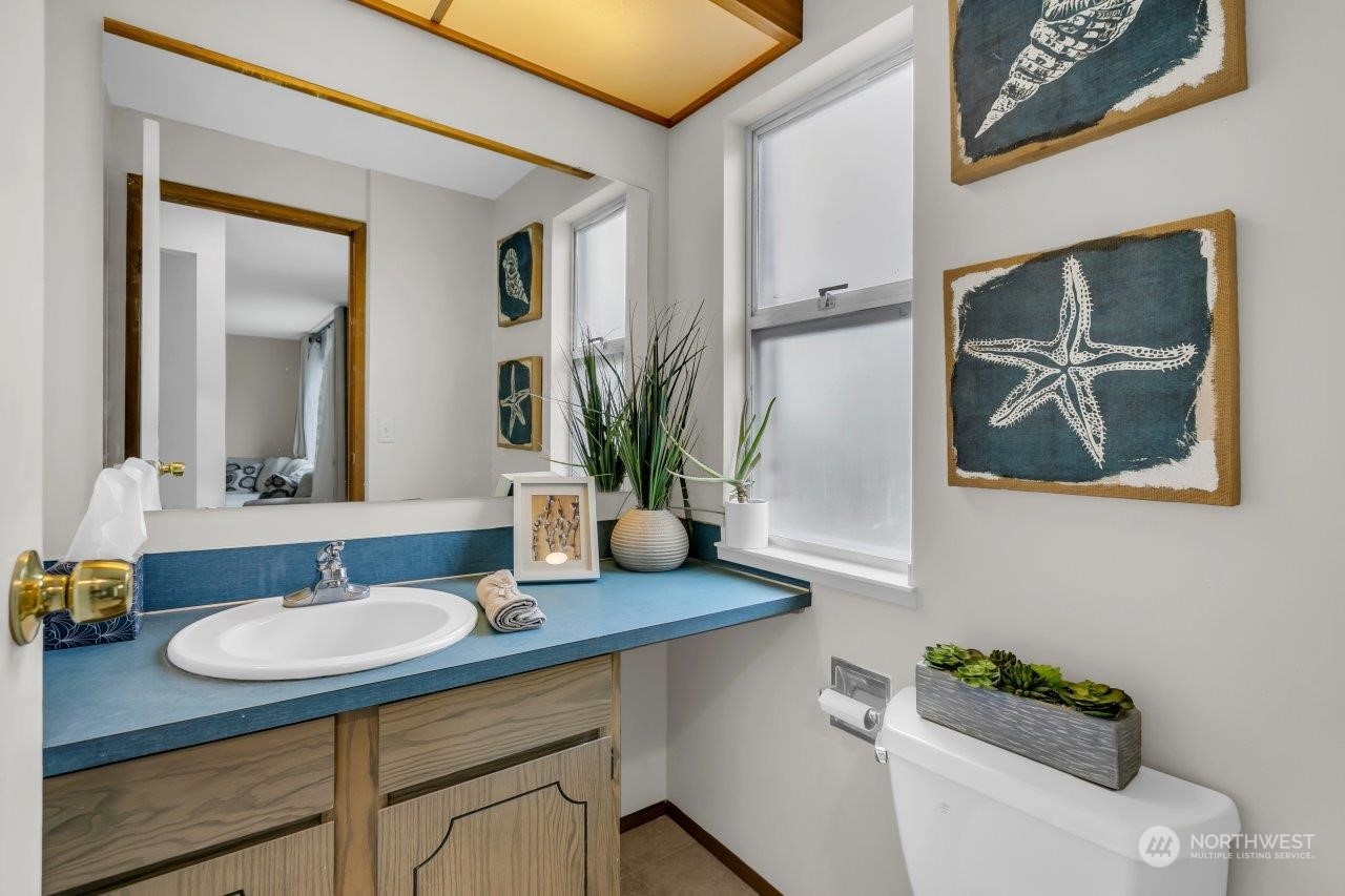 17043 159th Place Southeast Renton, WA 98058 - Photo 16 of 30 a bathroom with a granite countertop sink a mirror and a potted plant
