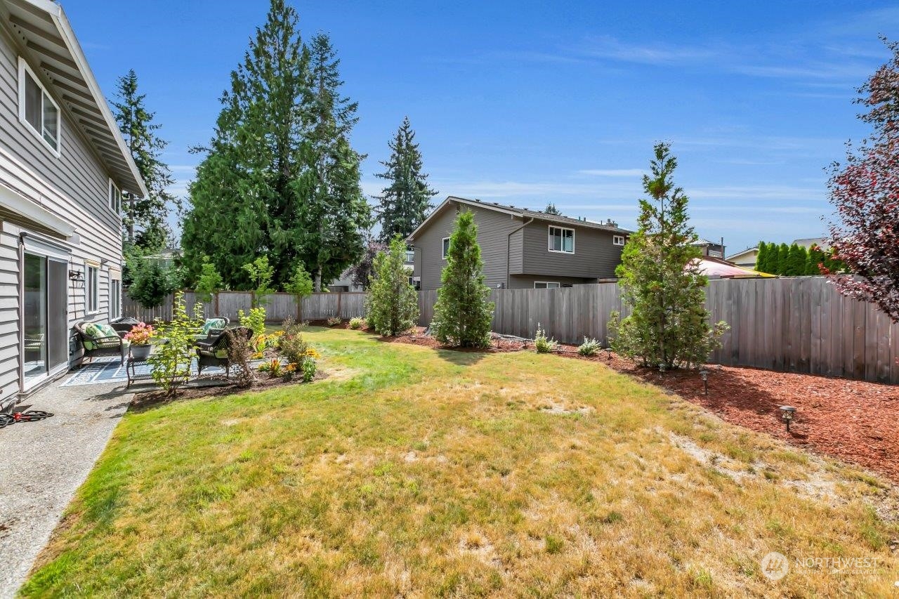 17043 159th Place Southeast Renton, WA 98058 - Photo 24 of 30 a view of a backyard with table and chairs and wooden fence