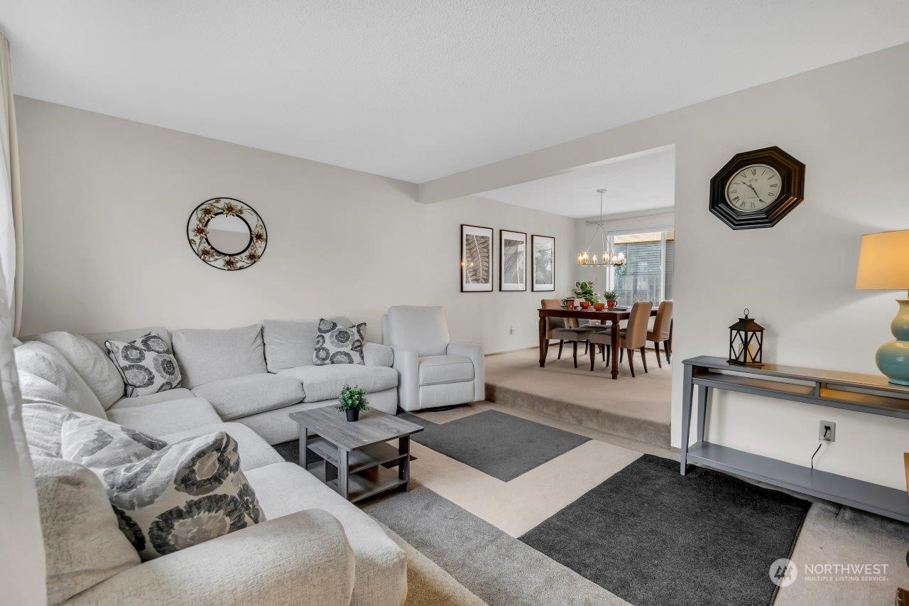 17043 159th Place Southeast Renton, WA 98058 - Photo 6 of 30 a living room with furniture a clock on wall and a window