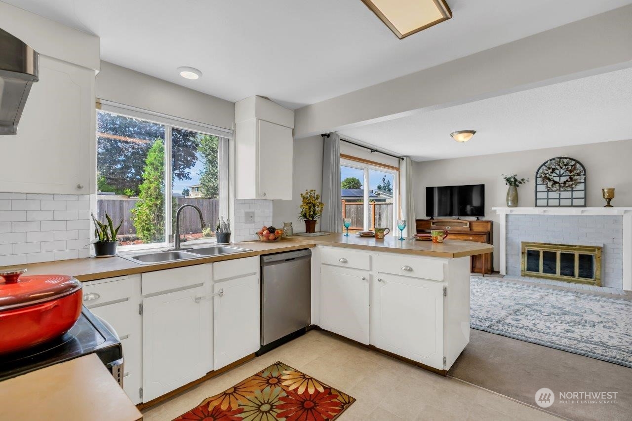 17043 159th Place Southeast Renton, WA 98058 - Photo 10 of 30 a large kitchen with stainless steel appliances granite countertop a stove sink and window