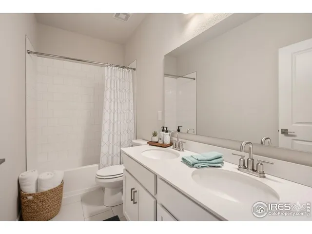 a bathroom with a double vanity sink toilet and a mirror