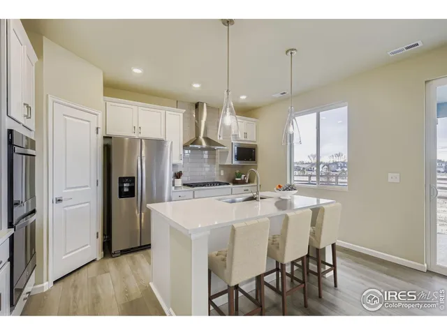 a kitchen with refrigerator cabinets and wooden floor