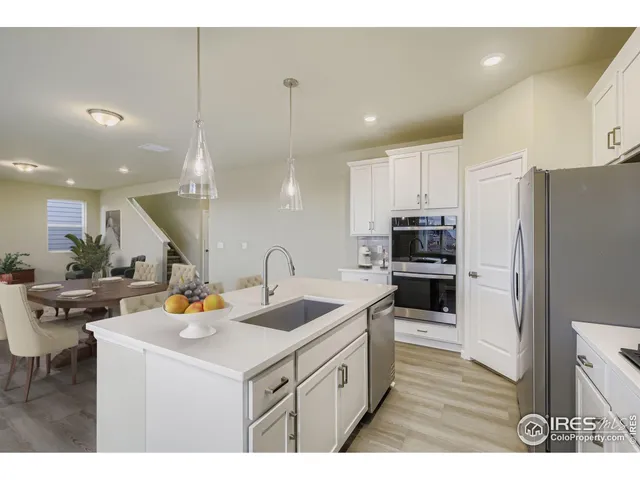 a kitchen with a sink a stove and chairs