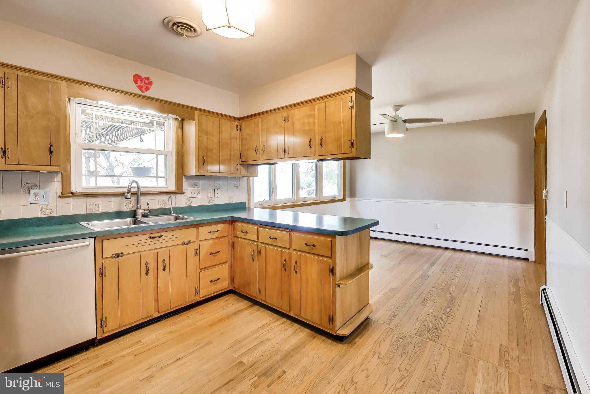 3904 Overlook Lane Monrovia, MD 21770 - Photo 14 of 54 a kitchen with stainless steel appliances granite countertop a stove a sink and white cabinets with wooden floor next to windows